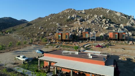 toma aérea de un viñedo y un pequeño hotel en el valle de guadalupe