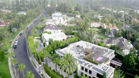 drone low view over beverly hills neighborhood luxury mansion, villa, homes with swimming pools, tennis courts