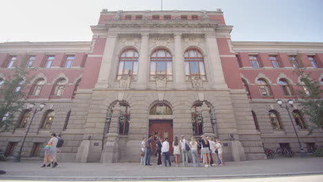 supreme court of norway facade with people gathered in front, oslo. establisher