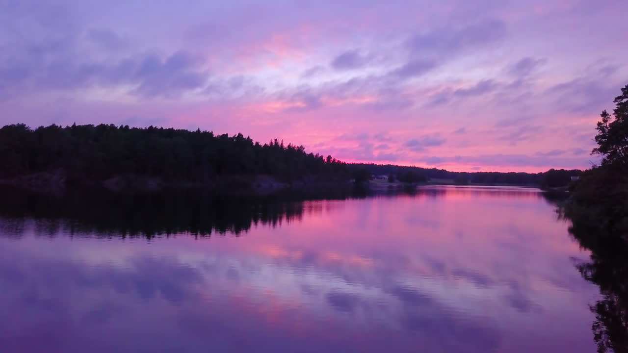 Panoramica lenta di un lago, con cielo viola, tramonto o crepuscolo colorato, ad Albysjon, Tyreso, Svezia