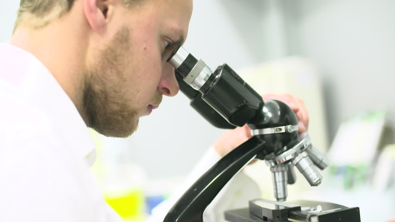 Scientist Looking Through Microscope in a Laboratory
