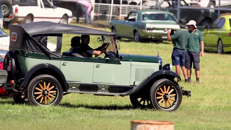 vintage car driving through a car show