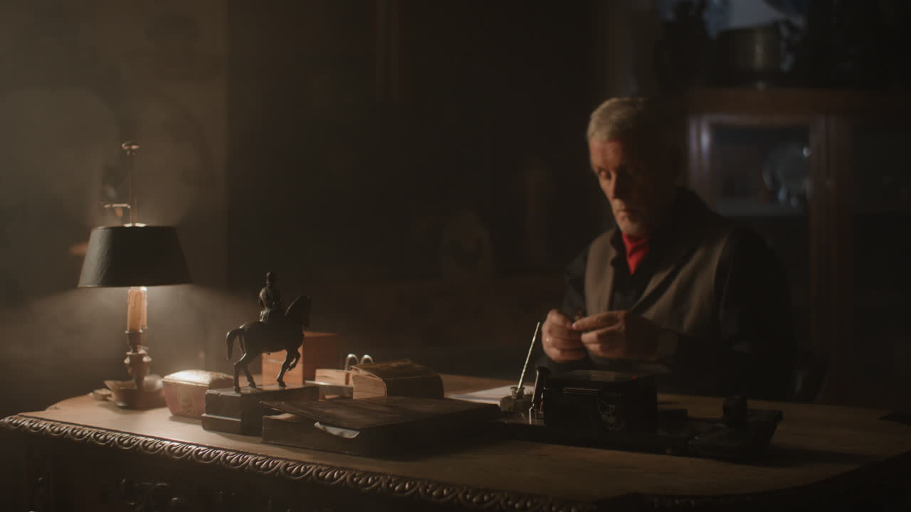 Old passionate man writes down a note in his office at night