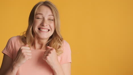 caucasian woman getting excited and showing thumbs up on camera.