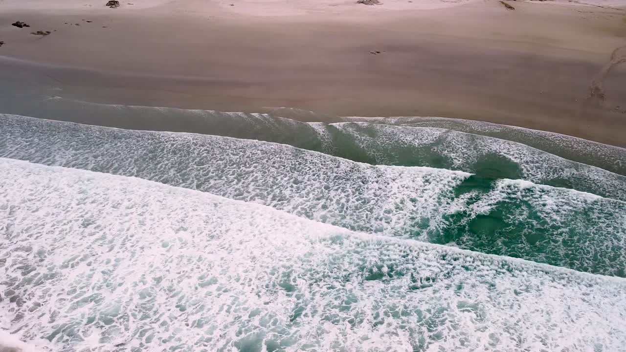 vista aérea de drones de las olas de surf espumosas en la playa de caion en galicia, españa