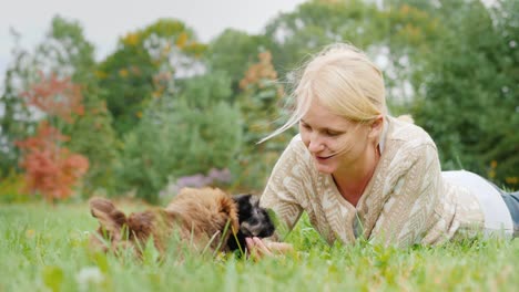 time together with your favorite pets. a middle-aged woman playing with two puppies