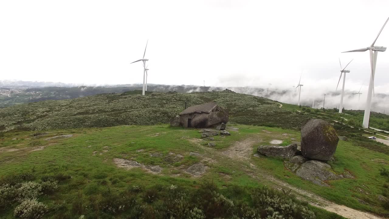 сельский дом с ветряными турбинами в туманный день воздушный вид
