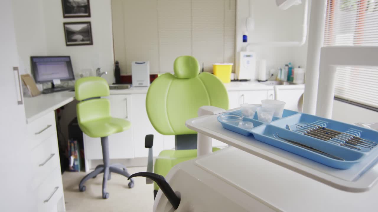 interno vuoto della clinica dentale con sedia dentale verde e strumenti