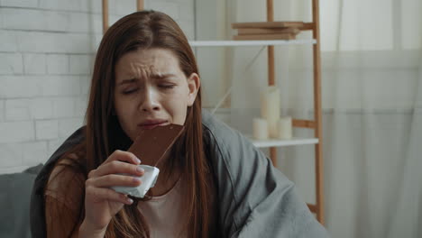 woman eating chocolate while crying