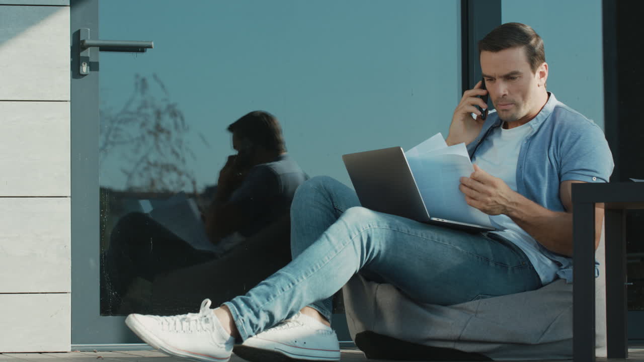 Serious man talking on mobile and looking documents