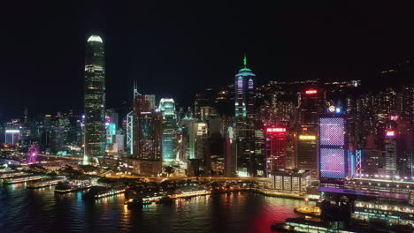 hong kong island skyline at night, central financial district. aerial side pan left to right