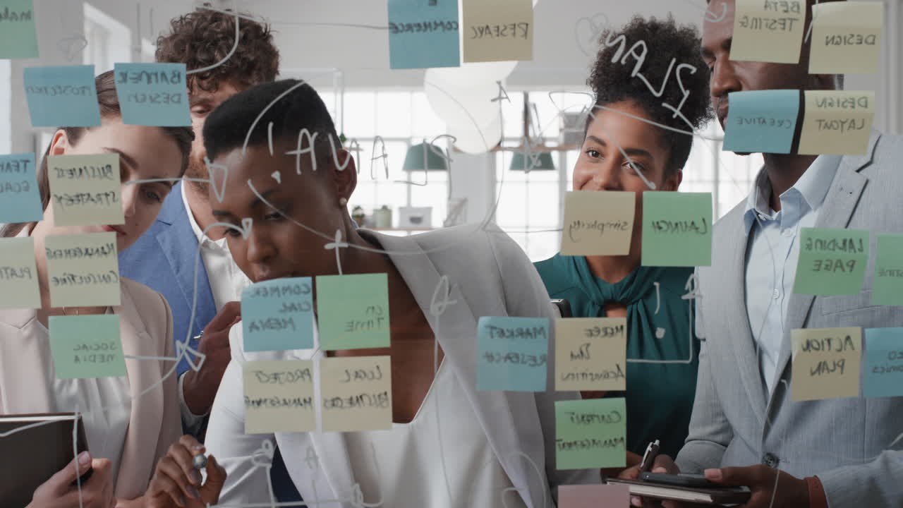 corporate business people using sticky notes brainstorming problem solving strategy on glass whiteboard team leader woman showing solution for project deadline in office meeting