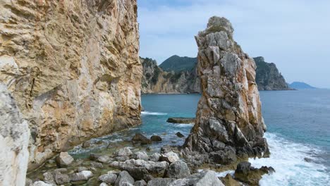 aéreo, bajo, sobrevuelo cercano a lo largo de la playa del acantilado rocoso en corfú, grecia, cámara lenta