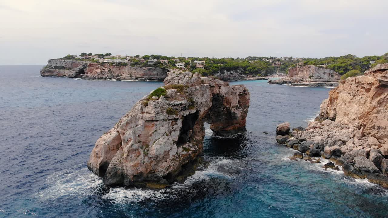 Panorama aereo sulle acque cristalline dell'isola di Maiorca che si infrangono sulle scogliere rocciose circostanti. Spagna