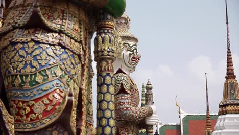 static shot of the warrior-demon statues at wat phra kaew temple complex and grand palace in bangkok, thailand