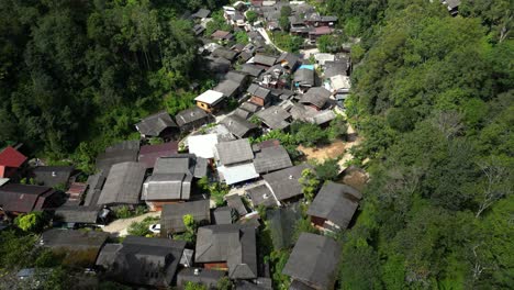 Tilt-up-drone-reveal-of-lush-jungle-with-hidden-village-in-Thailand