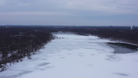 an aerial view from a drone, over a long lake during sunrise on a cloudy morning