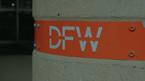 texas, dallas fort worth airport dfw signage on concrete column with orange background