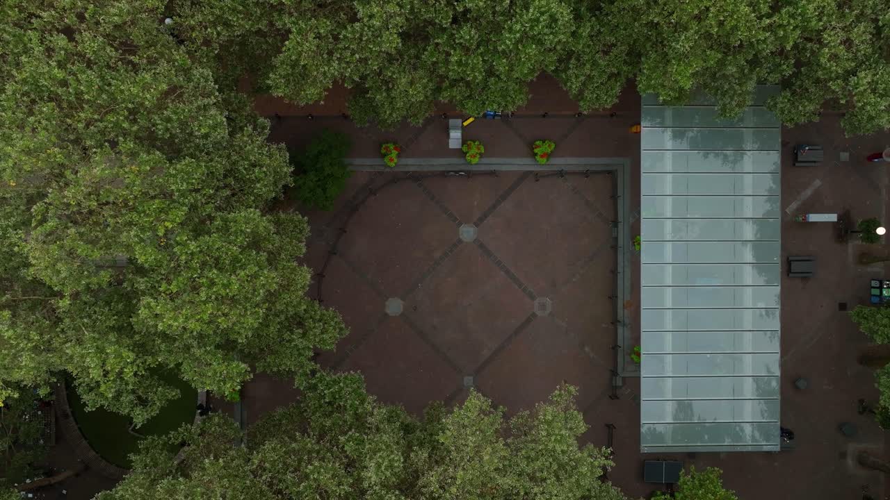 Rising aerial view of Occidental Square in downtown Seattle, surrounded by trees