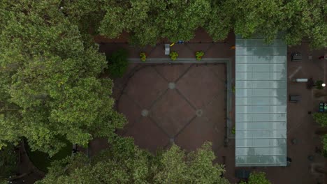 Rising-aerial-view-of-Occidental-Square-in-downtown-Seattle,-surrounded-by-trees