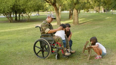 niños felices disfrutando del tiempo libre con papá y mamá militares discapacitados