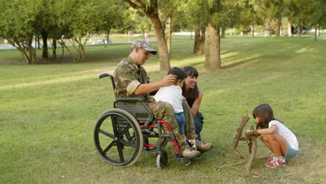 happy kids enjoying leisure time with handicapped military dad and mom