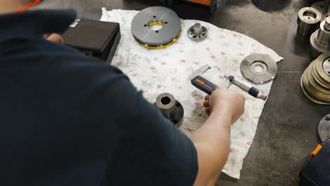 Worker-measuring-metal-part-with-micrometer-in-workshop,-close-up,-industrial-setting