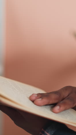 man turns book page in university library closeup. african american student reads educative literature before tests in information center. book store