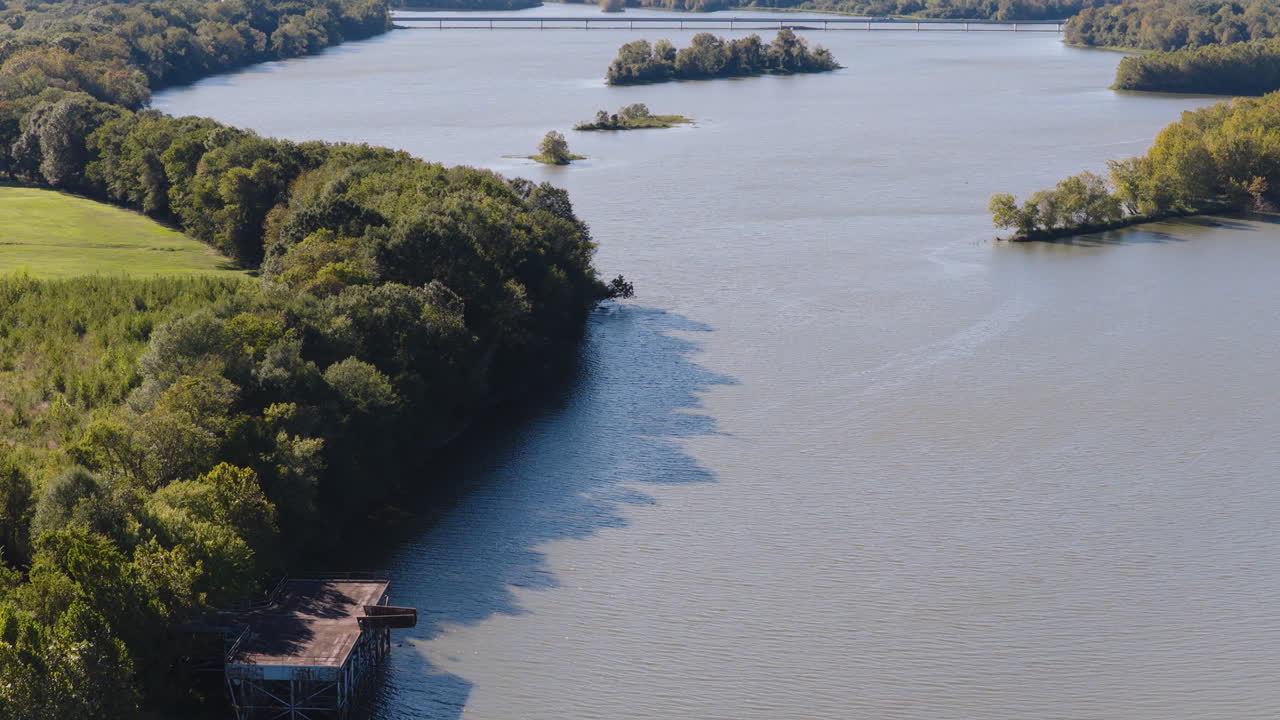 Piattaforma di legno nel fiume con sponde fluviali densamente boscose in estate. - Ripresa aerea