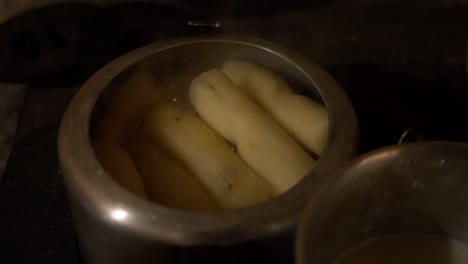 a pot full of paraguayan cassava with an appetizing and homey appearance, in a classic kitchen with wood and fire in the background