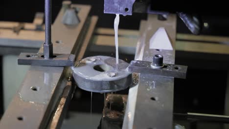 máquina cnc edm mientras corta las piezas de trabajo de muestra. corte de metal tecnología de procesamiento moderno haciendo detalles industriales.