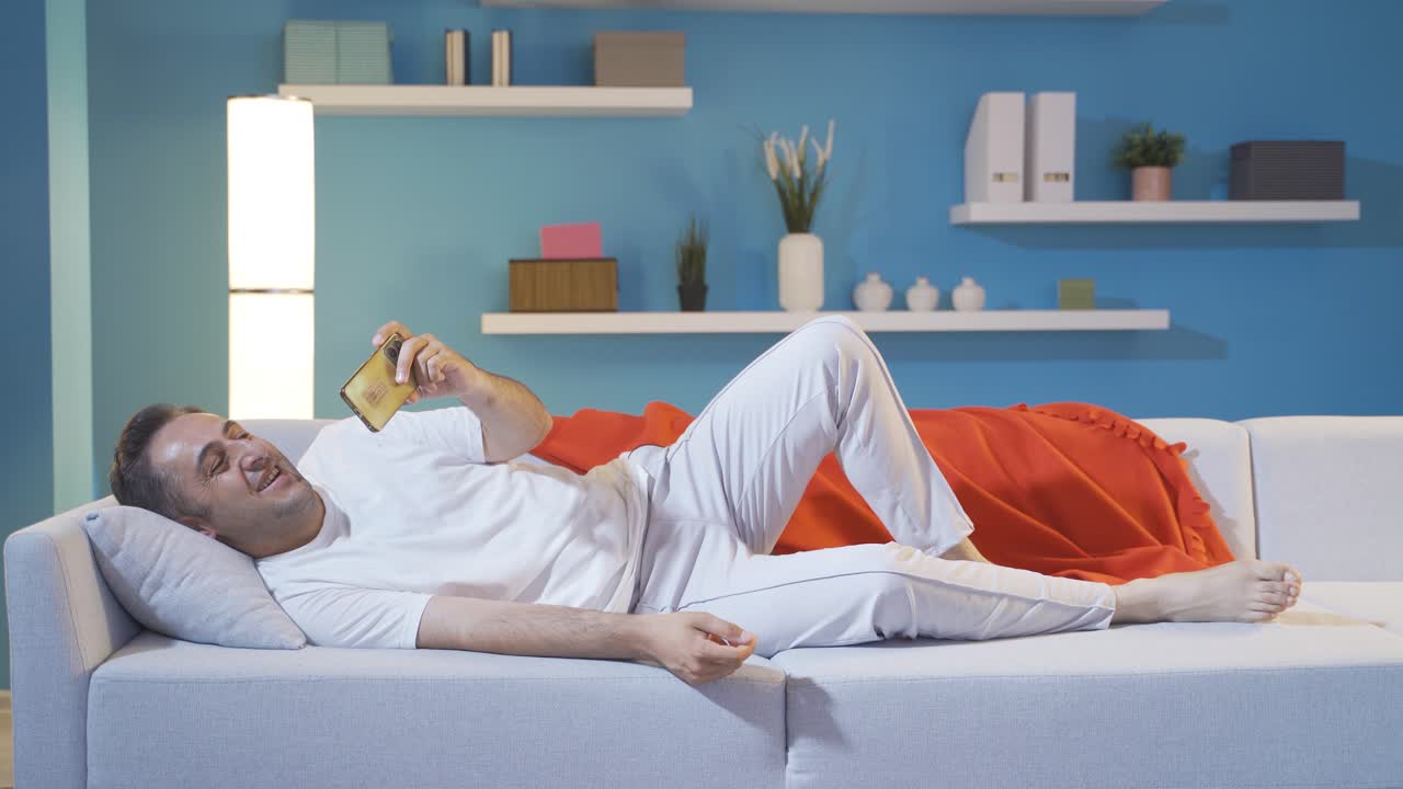 hombre riendo mirando el teléfono.