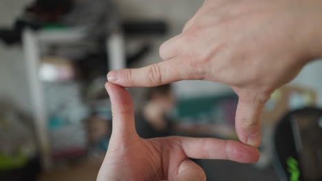 filmmaker framing a scene with hands in 16x9 ratio, focusing on a subject, pov shot with a handheld camera