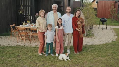 family and dogs posing in backyard