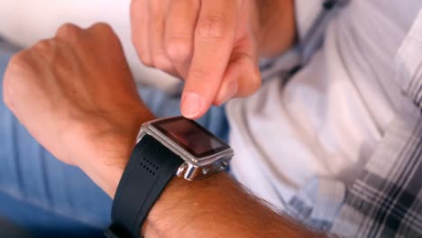 man using smart watch on couch