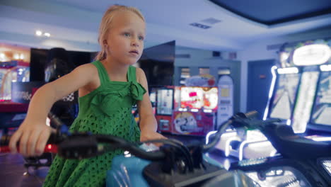 focused girl playing motorcycle arcade game