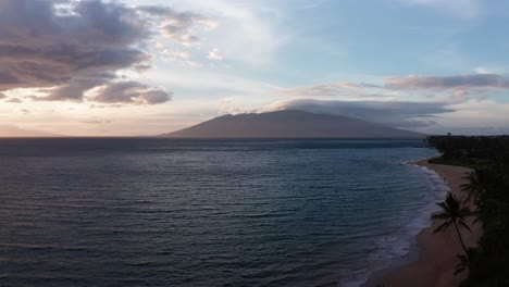 Low-aerial-rising-shot-of-West-Maui-from-Wailea-in-South-Maui-at-sunset-in-Hawai'i