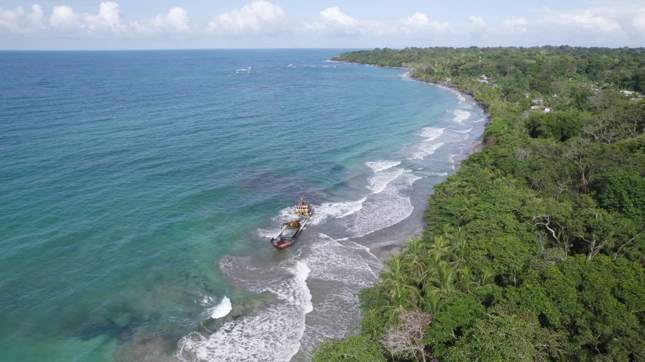 Aerial view of the Manzanillo Shipwreck against Costa Rica's lush tropical forest and pristine coastline. Circle Dolly Shot