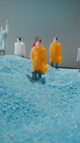 office workers with briefcases lost on way to work on blue sand shimmering at bright light . group of figures standing on sandy hill under grey sky macro