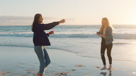 best friends blowing bubbles on beach at sunset teenage girls having fun summer playing by the sea enjoying friendship