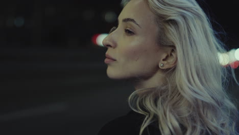 Female-face-looking-night-at-city-street-lights-in-urban-area.