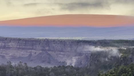 Cinematic long lens booming up shot of Mauna Loa at sunrise from Volcano House in Hawai&#039;i Volcanoes National Park