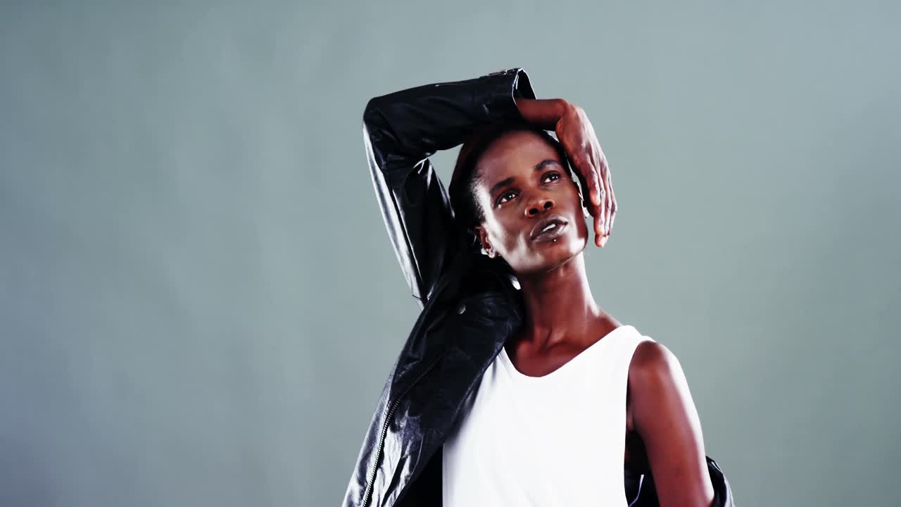 안드로기누스 남자가 유색 배경에 포즈를 취하고 있습니다.