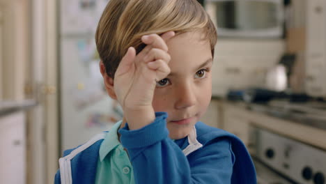 portrait-happy-little-boy-smiling-at-camera-running-hand-through-hair-cute-child-at-home-in-kitchen