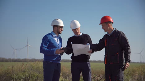 engineers reviewing plans at a wind farm site