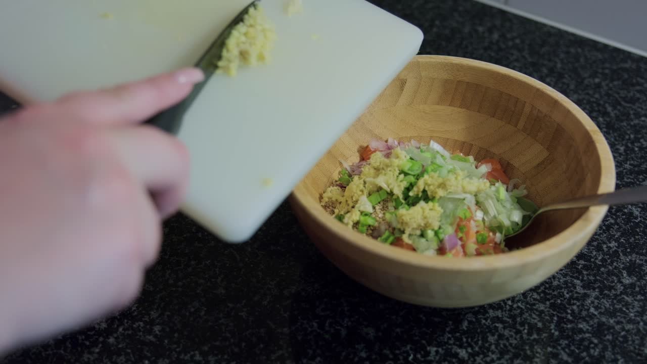 Woman's hands putting ginger in a wooden bowl, interior