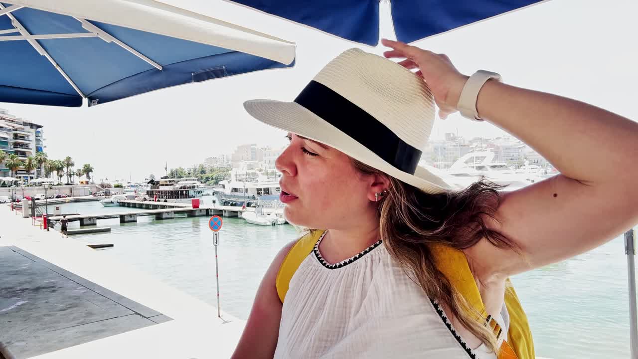 Woman relaxing at a cafe by the port