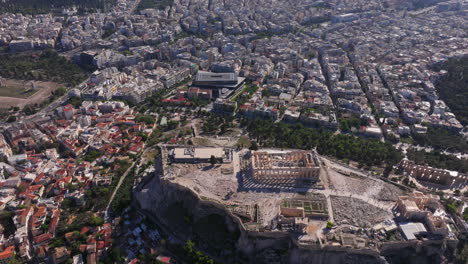 Toma-Aérea-Ascendente-De-La-Acrópolis-Con-El-Centro-De-Atenas-Debajo