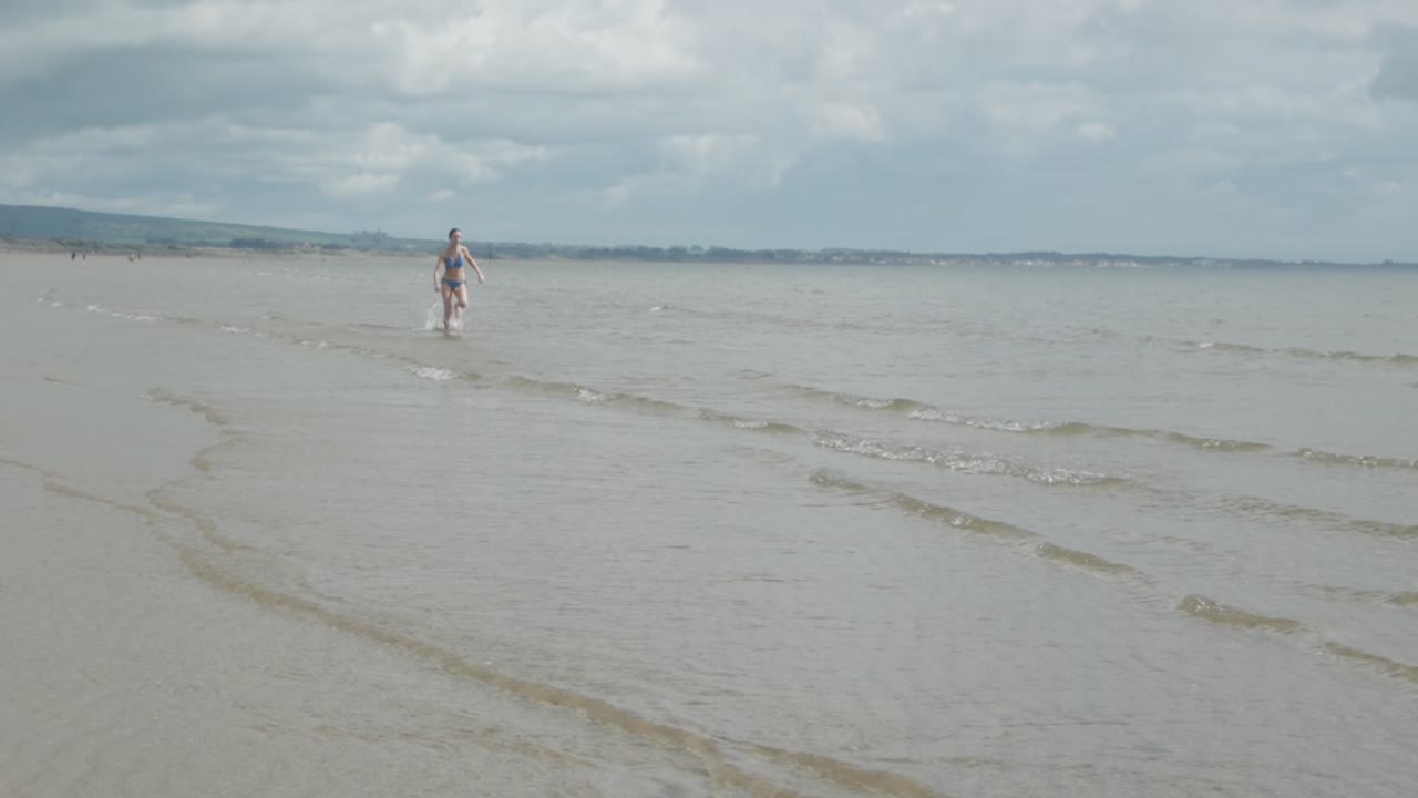 외 해안선을 따라 혼자 달리는 십대 여성, 느린 동작