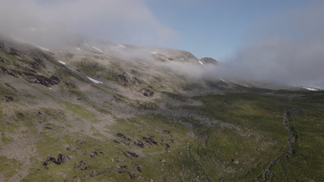 Bird's-Eye-View-Of-Mountain-With-Clouds-And-River-Streams-Of-Innerdalen-In-Romsdal-County,-Norway---drone-shot